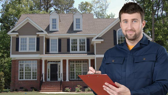 A home inspector in front of a house, going over the checklist.